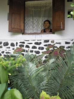 A Malagasy woman admires her garden from the window A Malagasy woman admires her garden from the window