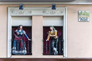 Man and woman sculptures with traditional Spanish dressed on the balconies, Paseo