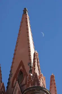 Mexico. A church steeple against a blue sky with the faint outline of the moon Mexico. A church steeple against a blue sky with the faint outline of the moon