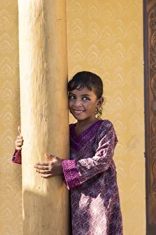 Middle East, Oman, Wahiba sands, a smiley bedouin girl wearing a pretty dress Middle East, Oman, Wahiba sands, a smiley bedouin girl wearing a pretty dress