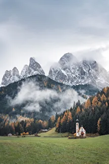 Misty moody autumn view of Santa Magdalena Church and Odle Mount in Trentino Alto Adige Misty moody autumn view of Santa Magdalena Church and Odle Mount in Trentino Alto Adige