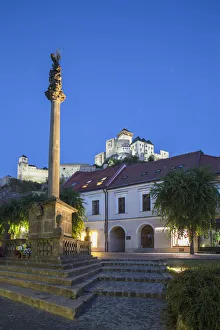 Monument in Mierove Square and Trencin Castle at dusk, Trencin, Trencin Region, Slovakia Monument in Mierove Square and Trencin Castle at dusk, Trencin, Trencin Region, Slovakia