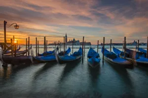 Moored gondolas at sunrise with San Giorgio Maggiore island in the background, Venice Moored gondolas at sunrise with San Giorgio Maggiore island in the background, Venice