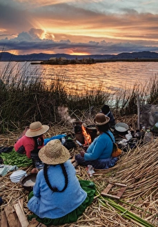 Native Uro Family dining at sunset, Uros Floating Islands, Lake Titicaca, Puno Region Native Uro Family dining at sunset, Uros Floating Islands, Lake Titicaca, Puno Region