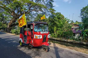 Negombo, Western Province, Sri Lanka, Southern Asia. A Red Tuk Tuk running in the streets Negombo, Western Province, Sri Lanka, Southern Asia. A Red Tuk Tuk running in the streets