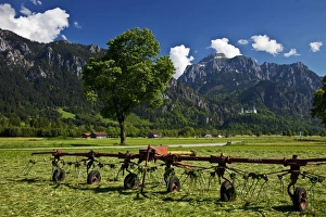 Neuschwanstein Castle in the distance with Farming equipment in the foreground Neuschwanstein Castle in the distance with Farming equipment in the foreground