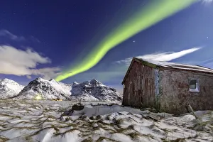Northern Lights over an abandoned log cabin surrounded by snow and ice Northern Lights over an abandoned log cabin surrounded by snow and ice