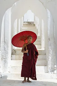 Novice monk with an umbrella standing at staircase hallway at Hsinbyume pagoda, Mingun Novice monk with an umbrella standing at staircase hallway at Hsinbyume pagoda, Mingun