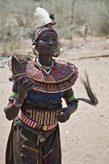 An old Pokot woman dancing during an Atelo ceremony. The cow horn container usually contains animal fat An old Pokot woman dancing during an Atelo ceremony. The cow horn container usually contains animal fat