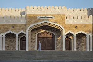 An Omani man walks in front of an ornate house in the village of Nakhal, Al-Batinah An Omani man walks in front of an ornate house in the village of Nakhal, Al-Batinah