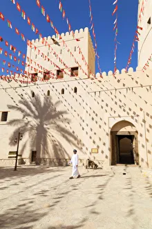 An Omani man walks past Bahla Fort decorated to celebrate the birthday of Sultan Qaboos An Omani man walks past Bahla Fort decorated to celebrate the birthday of Sultan Qaboos