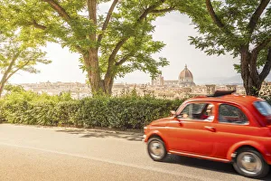 Original old red Fiat Cinquecento (500) with Florence Cathedral in background, Tuscany Original old red Fiat Cinquecento (500) with Florence Cathedral in background, Tuscany