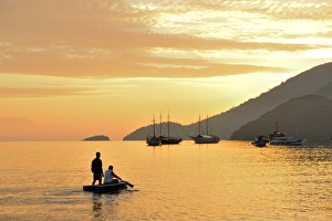 People on dingy paddeling out to ship, cove at Vila do Abrao, Ilha Grande, Rio de Janeiro People on dingy paddeling out to ship, cove at Vila do Abrao, Ilha Grande, Rio de Janeiro