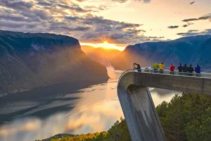 People photographing sunset on the fjord from Stegastein viewpoint, aerial view People photographing sunset on the fjord from Stegastein viewpoint, aerial view