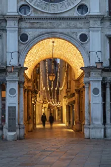 People walk through the illuminated arcade under the clock Tower, St People walk through the illuminated arcade under the clock Tower, St