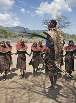 A Pokot warrior wearing a cheetah skin jumps high in the air surrounded by young women to celebrate an Atelo ceremony A Pokot warrior wearing a cheetah skin jumps high in the air surrounded by young women to celebrate an Atelo ceremony