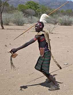 A Pokot warrior wearing a leopard skin cape celebrates an Atelo ceremony, spear in hand A Pokot warrior wearing a leopard skin cape celebrates an Atelo ceremony, spear in hand