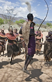 A Pokot warrior wearing a leopard skin jumps high in the air surrounded by women to celebrate an Atelo ceremony A Pokot warrior wearing a leopard skin jumps high in the air surrounded by women to celebrate an Atelo ceremony