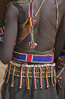A Pokot woman in traditional attire with patterned cicatrices on her back attends an Atelo ceremony A Pokot woman in traditional attire with patterned cicatrices on her back attends an Atelo ceremony