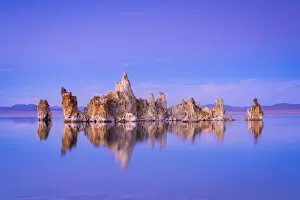 Reflection of rock formation in South Tufa on Mono Lake against blue sky at dusk