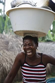Images Dated 22nd August 2006: A Sao Tomense woman laughs while carrying her washing up on her head