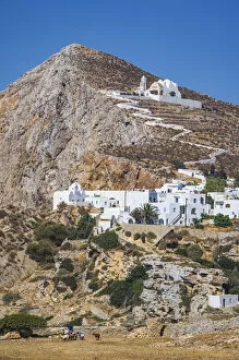 shepherd with goats and the Hora Village in Folegandros, Cyclades Islands, Greece