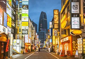Shinjuku, Tokyo, Kanto region, Japan. Illuminated neon signs at dusk and Cocoon Tower