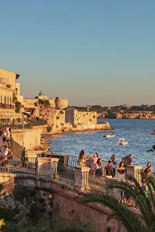 Siracusa, Sicily. People walking by the sea at sunset Siracusa, Sicily. People walking by the sea at sunset