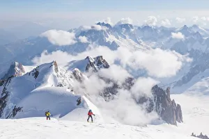 Ski mountaneers on the top of Mount Blanc with peaks in background Ski mountaneers on the top of Mount Blanc with peaks in background