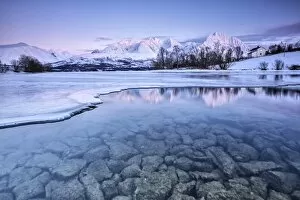Serene Landscapes Gallery: Snowy peaks are reflected in the frozen Lake Jaegervatnet at sunset Stortind Lyngen Alps Tromsa¸ Lapland Norway Europe
