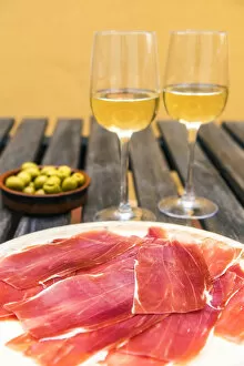 Images Dated 4th September 2017: Spanish ham or jamon iberico served with glasses of white wine and olives in a tapas bar