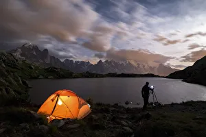 Tent and photographer in front of Mont Blanc from Lac de Chesery during summer night Tent and photographer in front of Mont Blanc from Lac de Chesery during summer night