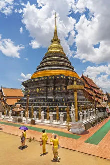 Thailand, Lampang, Wat Phrathat Lampang Luang, women walking infront of chedi Thailand, Lampang, Wat Phrathat Lampang Luang, women walking infront of chedi