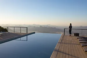 A tourist looks out at the view from the swimming pool at The View hotel, Al Hamra, Oman A tourist looks out at the view from the swimming pool at The View hotel, Al Hamra, Oman