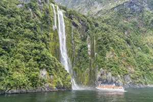 Touristic boat facing Stirling Falls in Milford Sound. Fiordland NP, Southland district Touristic boat facing Stirling Falls in Milford Sound. Fiordland NP, Southland district