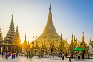 Tourists at gilded Shwedagon Pagoda against clear sky at sunrise, Yangon, Yangon Region Tourists at gilded Shwedagon Pagoda against clear sky at sunrise, Yangon, Yangon Region