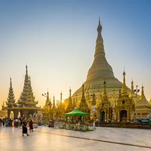 Tourists at golden Shwedagon Pagoda against clear sky at sunrise, Yangon, Yangon Region Tourists at golden Shwedagon Pagoda against clear sky at sunrise, Yangon, Yangon Region