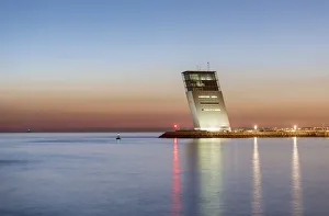 The Tower of Maritime Control in Alges at dusk, overlooking the Tagus river and the The Tower of Maritime Control in Alges at dusk, overlooking the Tagus river and the