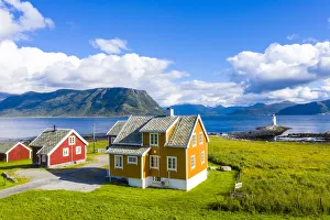 Traditional houses next to Hogsteinen Lighthouse by the sea, Godoya Island, Alesund Traditional houses next to Hogsteinen Lighthouse by the sea, Godoya Island, Alesund