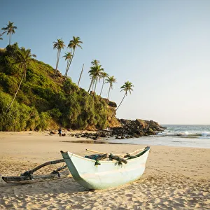 Traditional wooden boat on Talalla Beach at dusk, South Coast, Sri Lanka, Asia Traditional wooden boat on Talalla Beach at dusk, South Coast, Sri Lanka, Asia