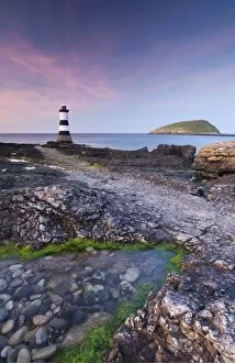 Images Dated 6th April 2011: Twilight on the rocky Anglesey coast looking towards Penmon Point Lighthouse and Puffin Island
