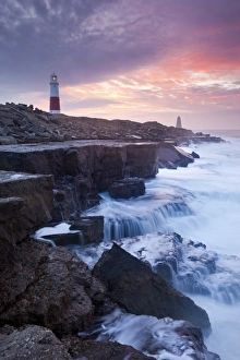 Waves crash against the limestone ledges near the lighthouse at Portland Bill, Dorset, England Waves crash against the limestone ledges near the lighthouse at Portland Bill, Dorset, England