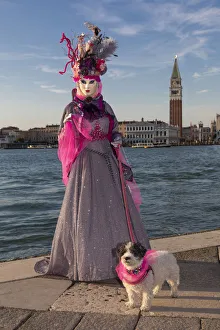 A woman and her dog pose in costume during the Venice Carnival, San Giorgio Maggiore A woman and her dog pose in costume during the Venice Carnival, San Giorgio Maggiore