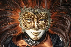 Carnival Collection: A woman in a feather Venetian mask poses during the Venice Carnival, Burano, Venice