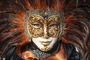 A woman in a feather Venetian mask poses during the Venice Carnival, Burano, Venice A woman in a feather Venetian mask poses during the Venice Carnival, Burano, Venice