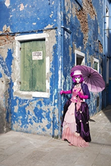 Woman in pink costume holding umbrella during Carnival, Island of Burano, Venice Woman in pink costume holding umbrella during Carnival, Island of Burano, Venice
