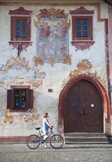 Woman walking past decorative building in Radnicne Square, Bardejov (UNESCO World Heritage Site) Woman walking past decorative building in Radnicne Square, Bardejov (UNESCO World Heritage Site)