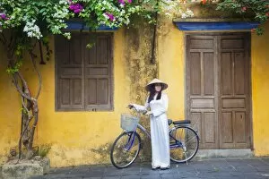 Images Dated 21st April 2014: Woman wearing Ao Dai dress with bicycle, Hoi An (UNESCO World Heritage Site), Quang Ham