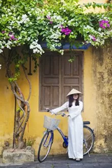 Images Dated 21st April 2014: Woman wearing Ao Dai dress with bicycle, Hoi An (UNESCO World Heritage Site), Quang Ham