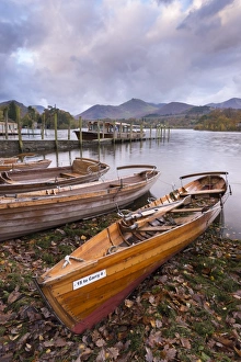 Wooden rowing boats beside Derwent Water in the Lake District, Cumbria, England. Autumn Wooden rowing boats beside Derwent Water in the Lake District, Cumbria, England. Autumn